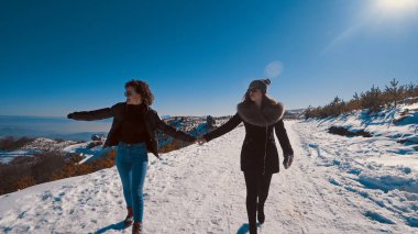 gülümseyen ve kış kar dağ üzerinde yürüyen iki güzel mutlu genç