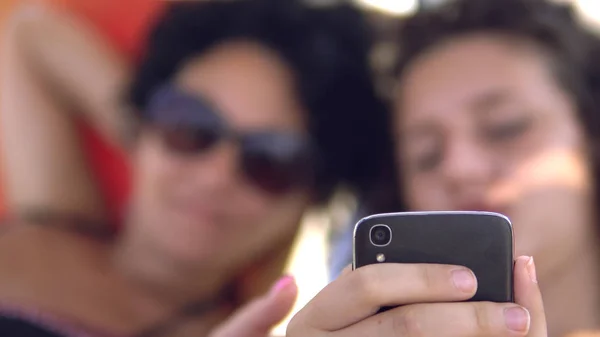 Teens Úsměv Náhled Sociální Média Příspěvky Smartphone Ležící Pláži Posteli — Stock fotografie
