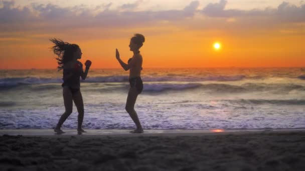 Zwei Mädchen Trainieren Karate Strand Vor Sonnenuntergang Und Wogenden Wellen — Stockvideo