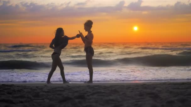 Zwei Mädchen Trainieren Karate Strand Vor Sonnenuntergang Und Wogenden Wellen — Stockvideo