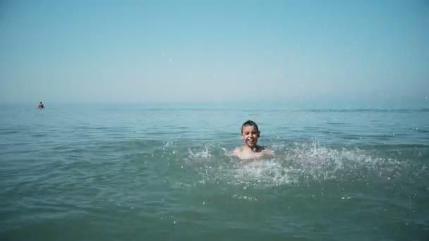 快乐男孩在海滩上的热带度假村的海水中飞溅 慢动作 — 图库视频影像