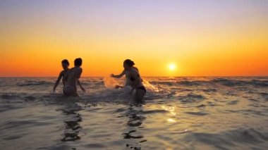 Aile insan bir parti spraing yaşıyorsanız ve yaz üzerinde atlama plaj gün batımı, sinematik ağır çekim