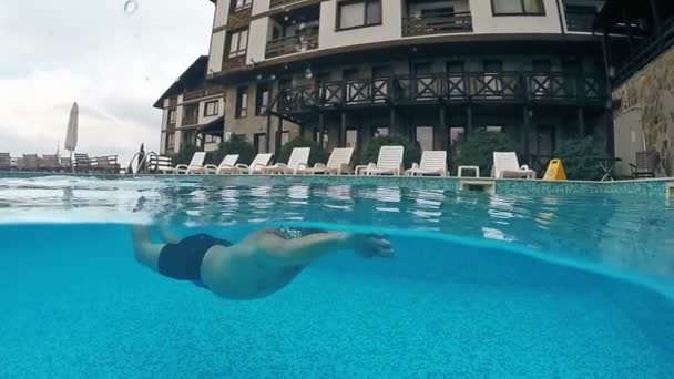 はぜのビラのプールで水中水泳グーグルで実業家 Gopro ドーム半水中ビュー スローモーション — ストック動画
