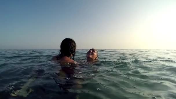 Two Happy Girls Play Drowning Game Sea Water Surface Sunset — Stock Video