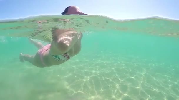 在水下游泳的时尚模特去水面深呼吸 高波圆顶半水下景观 — 图库视频影像