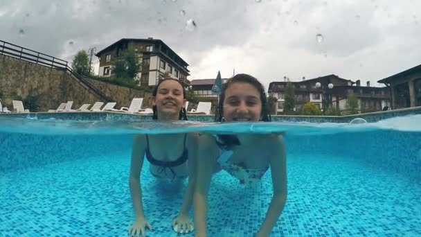 Twee Meisjes Plezier Ondiep Zwembad Glimlachend Grimaces Aanbrengen Camera Gopro — Stockvideo