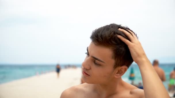 快乐的微笑英俊的年轻青少年微笑 并纠正他的发型和太阳镜在海滩上 Dof 暑假和人的概念 — 图库视频影像