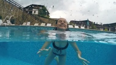 Yağmur hava gülümsüyor, havuzu yüzme diş diş telleri kızla, gopro kubbe yarım sualtı görünümü, ağır çekim