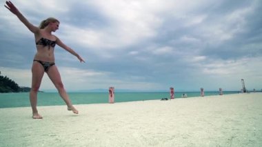 Güzel kız Beach iskelesinden, yavaş hareket jimnastik yaparken eğleniyor