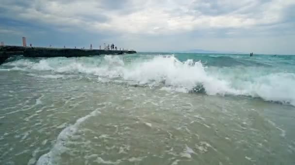 海浪在沙滩上破浪而去 有码头的背景 — 图库视频影像