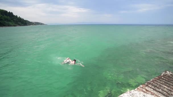 ターコイズ ブルーの海の水 スローモーション スローモーションで泳いでいる幸せな少年 — ストック動画
