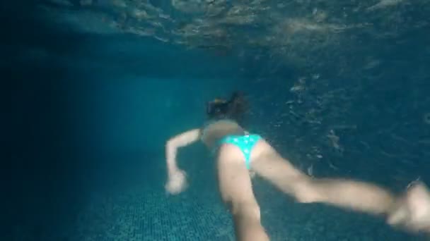 跟随女孩在室内黑暗的游泳池里在水下游泳 — 图库视频影像