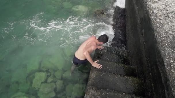 Schöner Sportlicher Junge Kommt Auf Der Hafentreppe Aus Dem Meerwasser — Stockvideo