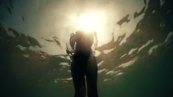 水中ハメ撮り観海バックライト 夏の日没の太陽を歩くセクシーなファッション モデル — ストック動画