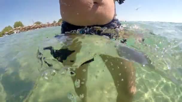 浅い海の水 Gopro で短パン散歩の男ドーム半水中ビュー — ストック動画