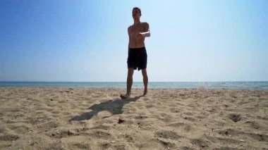 Handsome athlete male walk out of water on sea beach, cinematic steadicam shot, SLOW MOTION