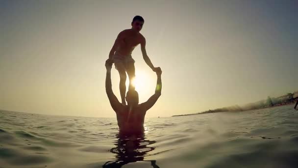 在日落的时候 年轻人从父亲的肩膀上跳来跳去 慢动作 — 图库视频影像