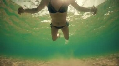 Kamera arkadan aydınlatmalı doğru yaz günbatımı güneş tarafından yüzme bikini seksi erkek ışınları, sualtı görüntüleme