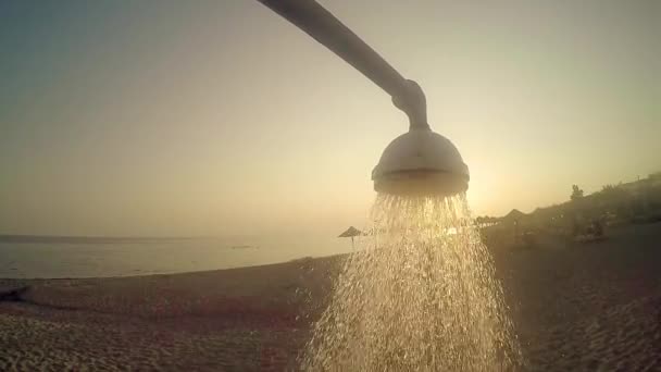 海滩头淋浴与自来水反对日落太阳 夏天概念 慢动作 — 图库视频影像