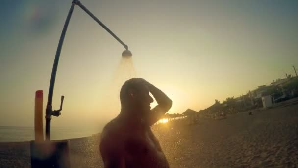 Άνθρωπος Λάβει Ντους Στο Ύπαιθρο Στην Παραλία Υπό Πρίσμα Ηλιοβασίλεμα — Αρχείο Βίντεο