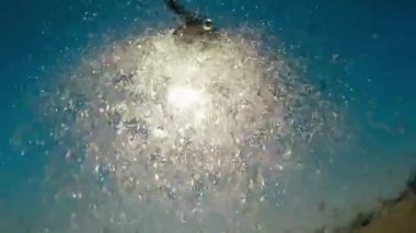 Güneş ve lens ile güzel mavi gökyüzü arka plan üzerinde ağır çekimde tatlı su ile duş açık plaj flare efektleri