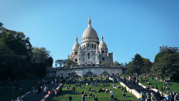 人们游客坐在巴黎蒙马特圣心大教堂下的楼梯上休息 电影拍摄 — 图库视频影像