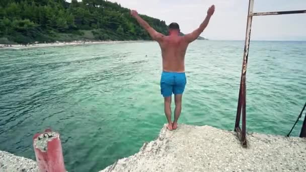 ターコイズ ブルーの海の水に飛び込む若い男 — ストック動画
