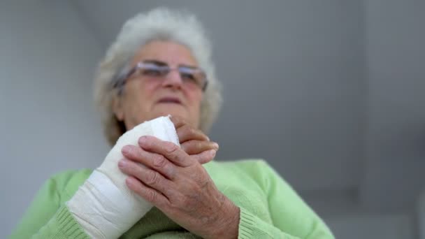 Alte Frau Massiert Ihre Verletzte Gebrochene Hand Sitzend Cineastische Dof — Stockvideo