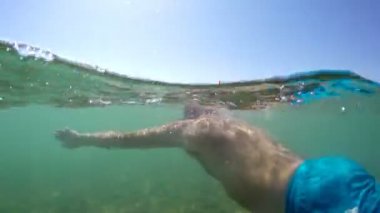 Snorkeling maske ile bir adam deniz su yüzeyine yüzme gopro kubbe yarım sualtı görüntüleme
