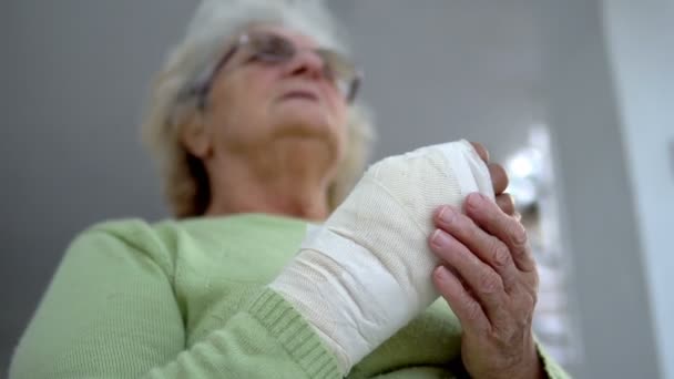 Old Woman Massage Her Injured Broken Hand Sitting Cinematic Dof — Stock Video