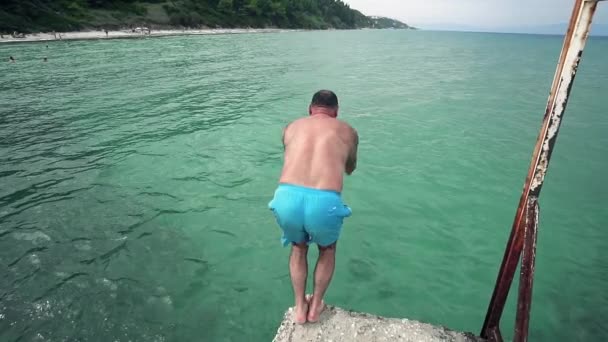 Junger Mann Springt Türkisfarbenes Meerwasser Zeitlupe — Stockvideo