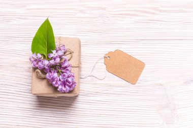 Hediye kutusu ahşap backgroubd üzerinde eflatun çiçekli