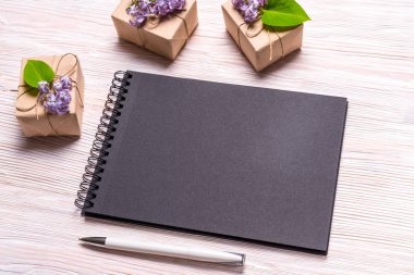 Siyah defter ve ahşap zemin üzerine sümbül çiçek