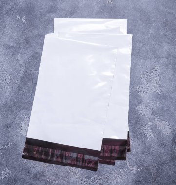Poli plastik mailler gri arka plan üzerinde zarf posta