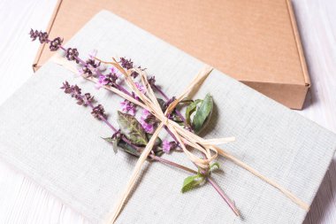 Karton hediye kutusu çiçeklerle sarılmış kitap 