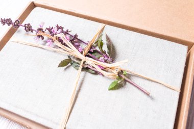 Karton hediye kutusu çiçeklerle sarılmış kitap 