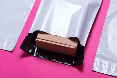 Pembe bir arka plan üzerinde polietilenler zarf kümesini