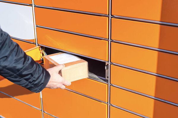 Человек кладет коробку на посылку машины
