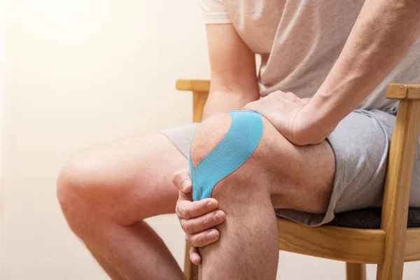 Man Sitting Chair Holding His Sore Knee Kinesiol — Stock Photo, Image