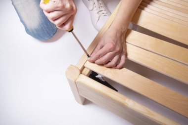 Woman hands assamble wooden boards frame for mattress  clipart