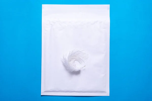 Lightweight bubble envelope with feather on blue background