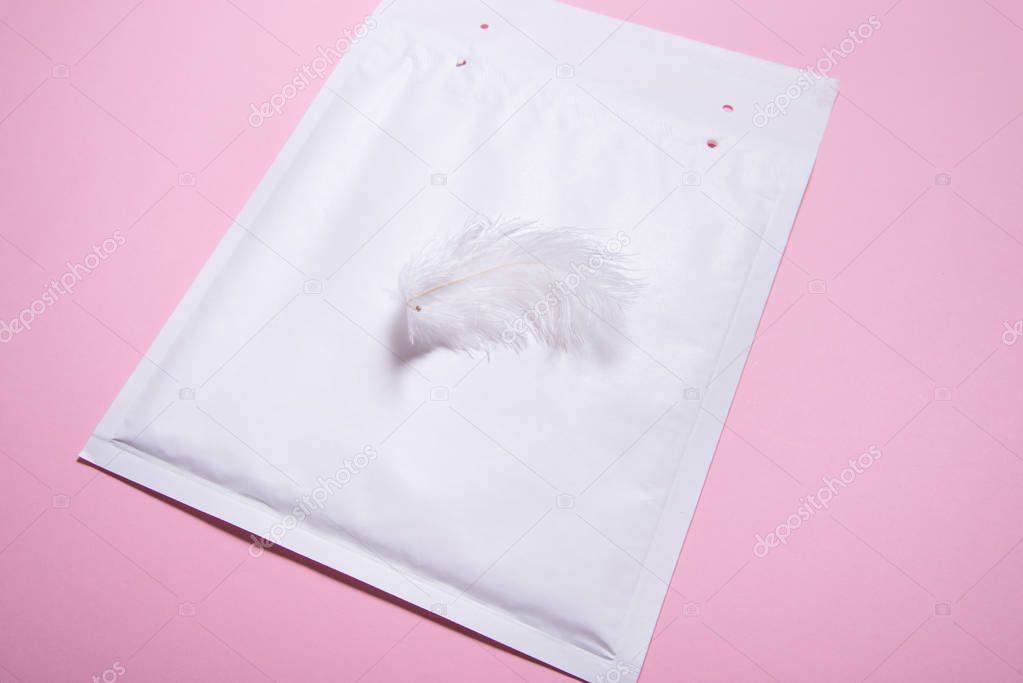 Lightweight bubble envelope with feather on pink background