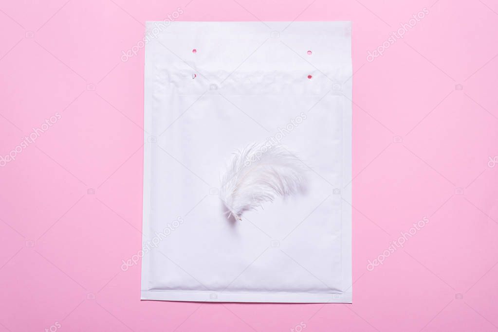 Lightweight bubble envelope with feather on pink background