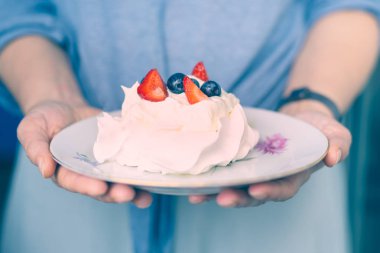 Beyaz kek, Meringue ile meyve ve çilek kadın elleri 