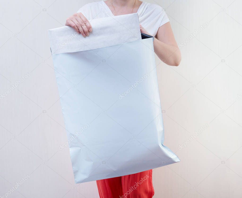 Woman holding big Poly plastic mailer mailing envelope