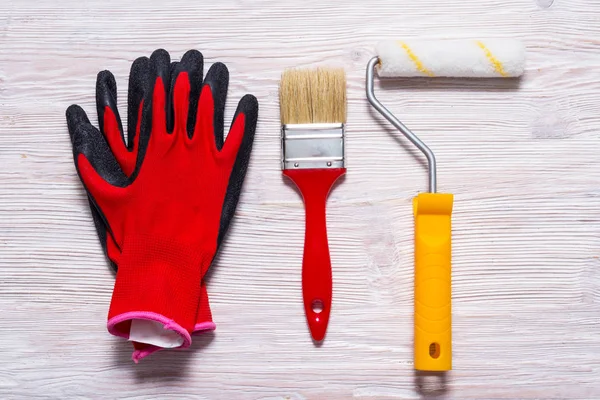 Decoradores herramientas sobre fondo de madera, guantes, cepillo, rodillo — Foto de Stock
