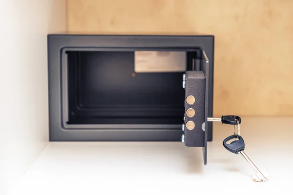 Открытый металлический сейф с ключом и открытая дверь в гостиничном номере, в — стоковое фото