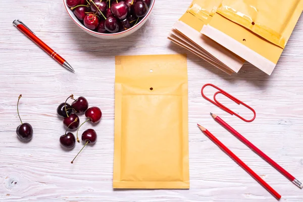 Caja de cartón sobre mesa de madera con cereza, concepto de verano — Foto de Stock