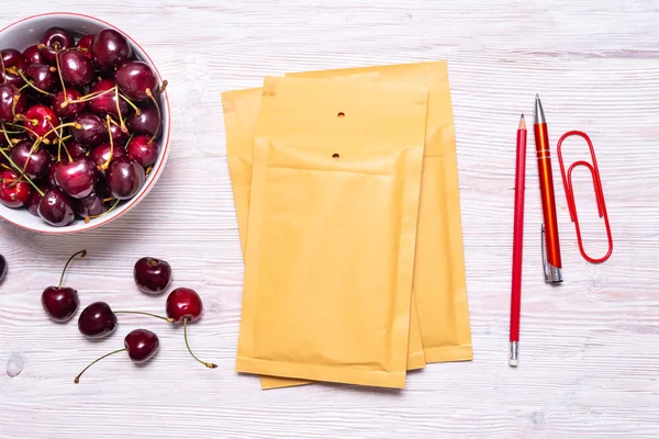 Caja de cartón sobre mesa de madera con cereza, concepto de verano — Foto de Stock