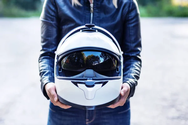 Mujer en chaqueta de cuero sostiene casco de motocicleta — Foto de Stock